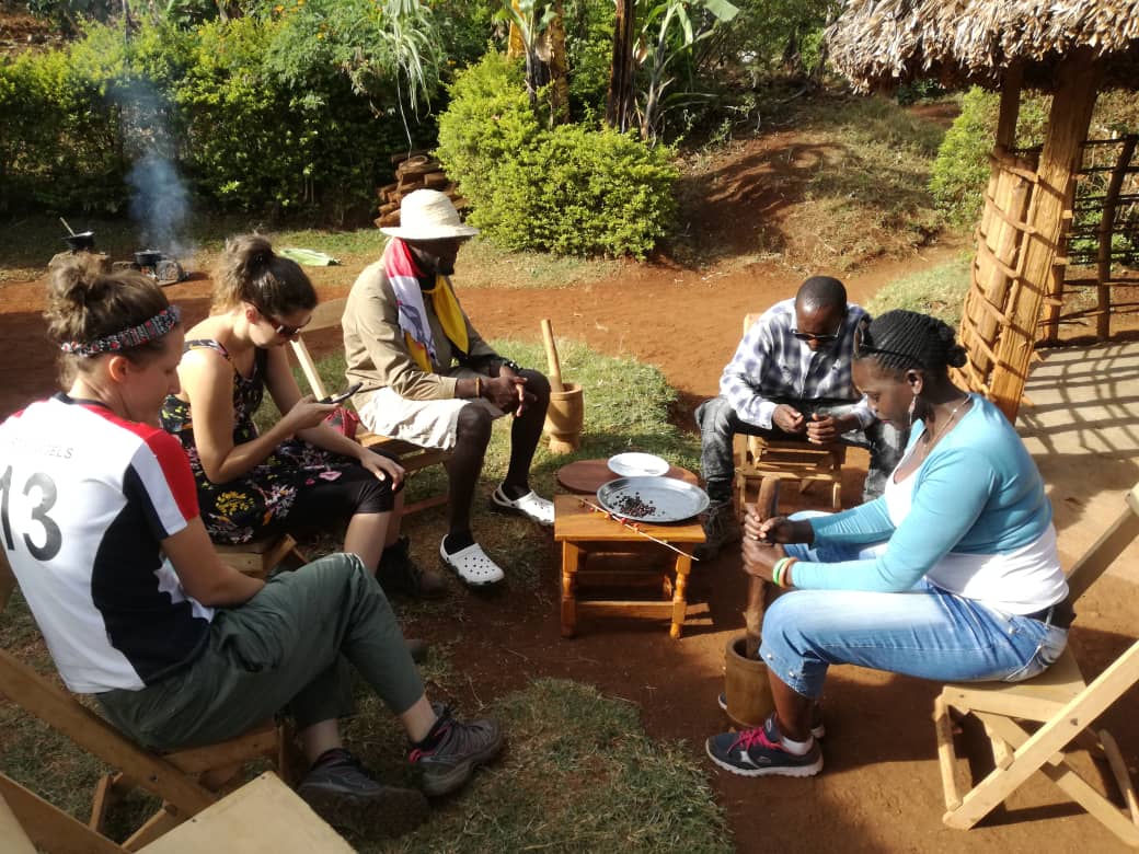 Guests pounding and sorting coffee with a local farming family near Sipi Falls, Uganda