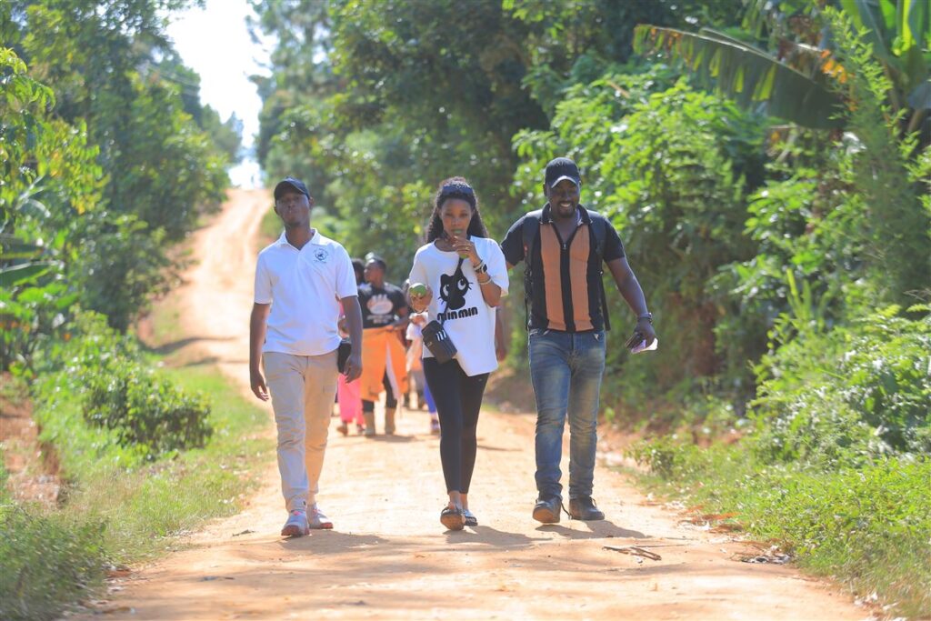 Guests walking along a village road with local guides near Kampala, Uganda